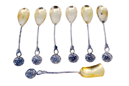 Conjunto de seis colheres de café em prata  e pá de açúcar recortadas com as conchas em dourado.